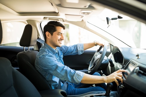 man changing radio station in car